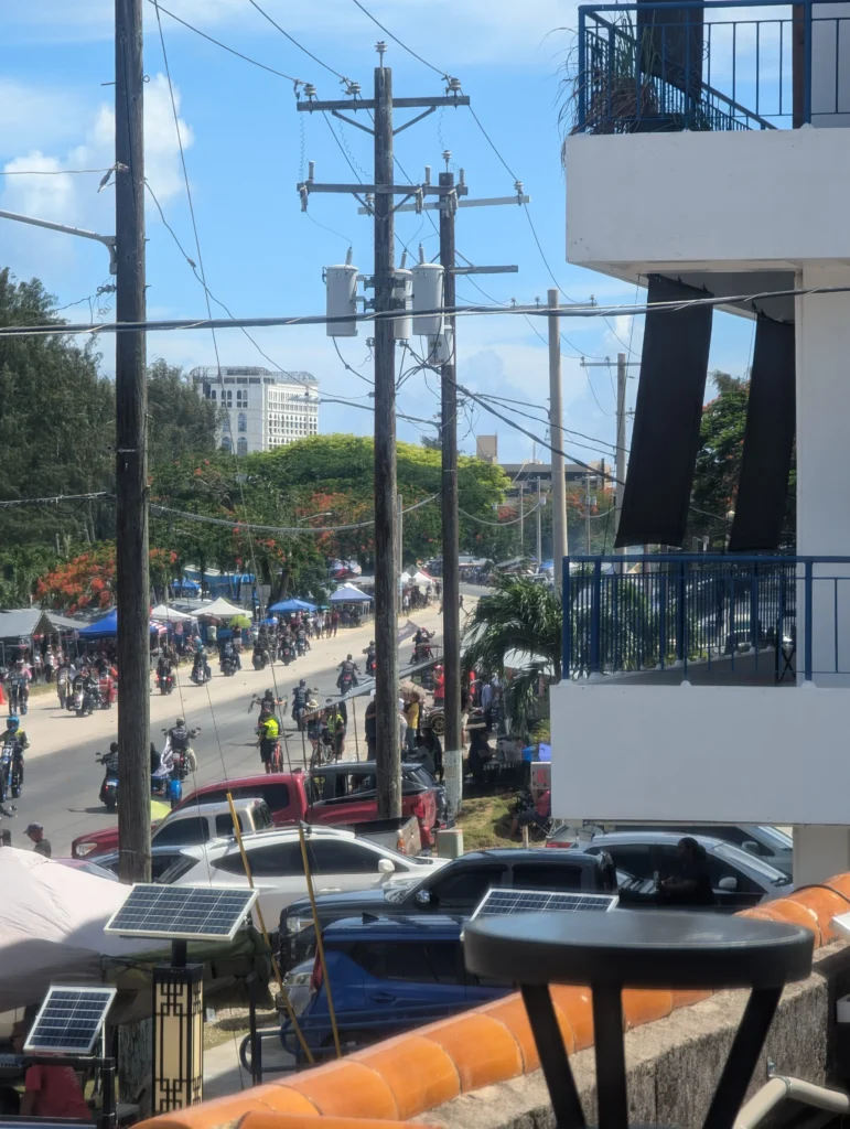 Liberation Day parade along Beach Road, Saipan. Free entertainment, community culture, and yes — those are solar panels in the foreground.